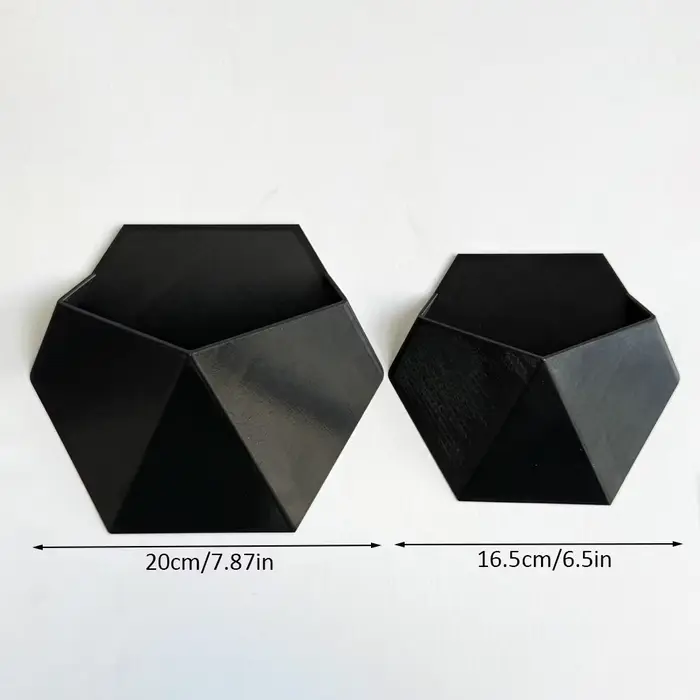 Le pot de fleurs hexagonal noir à fixer au mur a un design simple et unique. Sa structure perforée f